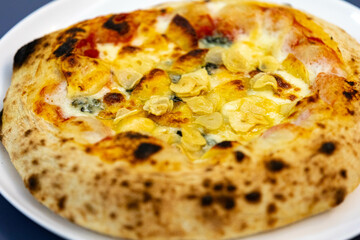 Traditional rustic pizza made with four cheeses, garlic and oil and pear with gorgonzola