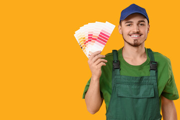 Young painter with color palettes on yellow background