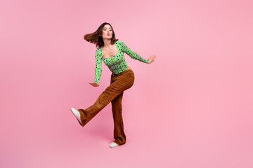 Photo of adorable cheerful woman wear green stylish clothes dance empty space isolated on pink color background