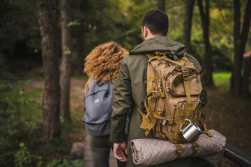 Fototapeta premium back view of hiker couple husband and wife stamp through the forest