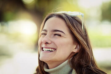 Face, funny and smile with woman at park, outdoor for comedy, humor or wellness in summer. Eyes closed, laughing and joyful with happy person in garden or nature for holiday, travel or vacation