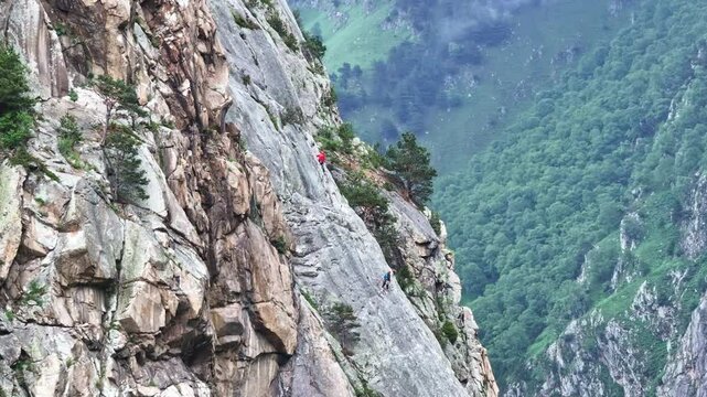 Two climbers make their way up a steep mountain face