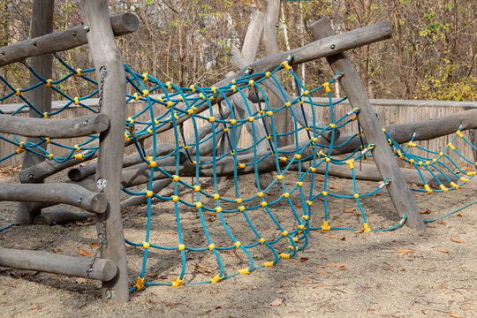 Children's playground made of wood and mesh. Construction with spider web obstacles
