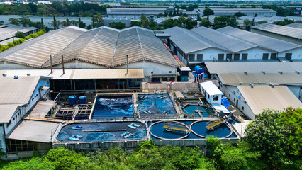 A wastewater treatment plant with tanks and filters processes factory liquid waste, ensuring it's clean before disposal. Pipes and machinery manage the flow efficiently.