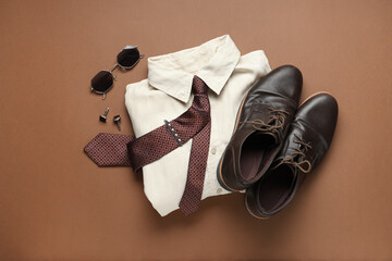Stylish men's accessories with shirt and shoes on brown background
