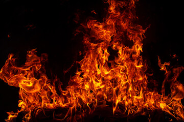 Obraz premium Fire blaze flames on black background. Fire burn flame isolated, abstract texture. Flaming explosion with burning effect. Fire wallpaper, abstract art pattern.