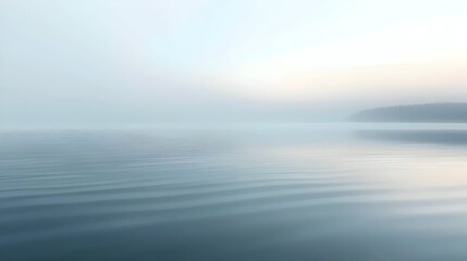 Obraz premium A serene landscape featuring calm water shrouded in soft morning fog, creating a tranquil atmosphere that invites reflection and peace.