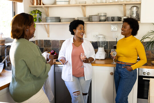 African american female friends chatting during thanksgiving gathering, at home