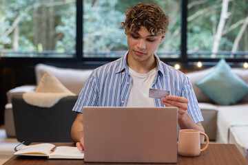 Christmas time, At home, young man using laptop and credit card for online shopping