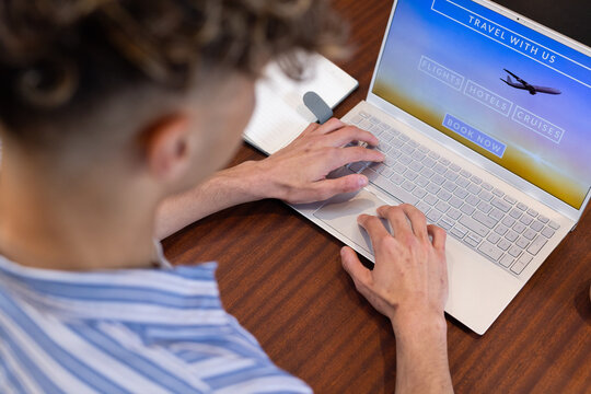 Booking travel online, man using laptop at desk, planning holiday trip, at home - Powered by Adobe