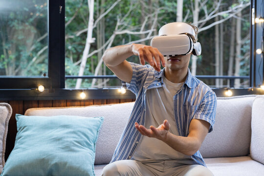 Christmas time, man using VR headset on sofa, exploring virtual world at home