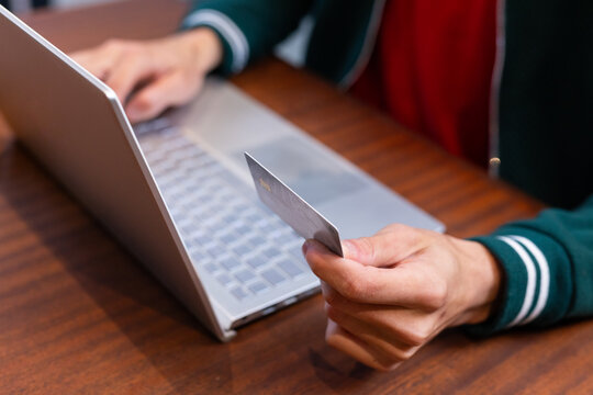 man shopping online with credit card using laptop at home