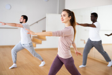 Young attractive woman visiting group choreography class, learning modern dynamic dances. Concept...
