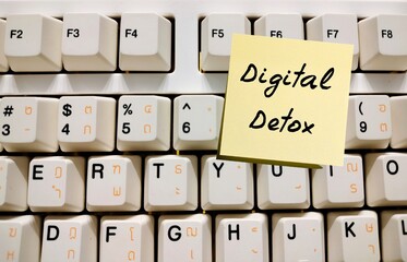 Stick note on computer keyboard with handwritten text Digital Detox  - take a break from smartphone...