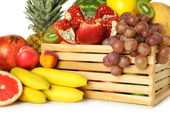 Wooden crate with many different fresh fruits isolated on white