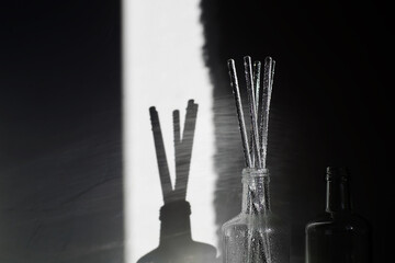 Abstract backgrounds glass bottle, shadow and sunlight on white background, bokeh lights on glass. Horizon black and white photography.