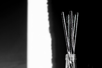 Abstract backgrounds glass bottle, shadow and sunlight on white background, bokeh lights on glass. Horizon black and white photography, colored water drops.