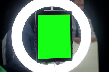 tab with green screen and ring light