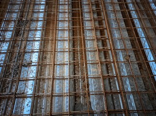 Obraz premium The image shows a grid of steel bars, called rebar, used to reinforce concrete. This grid is placed before concrete is poured to strengthen the structure. 