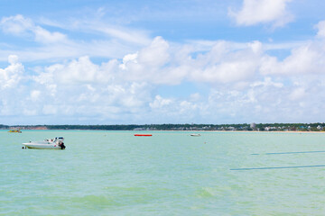 A calm day at sea with a speedboat in the background in Jo&atilde;o Pessoa, Para&iacute;ba, Brazil.