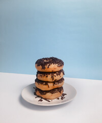 Chocolate donuts with messes on blue background