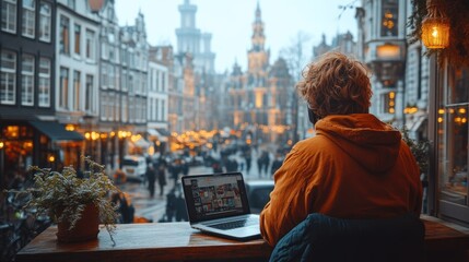 Naklejka premium Person working on a laptop in a scenic city view.
