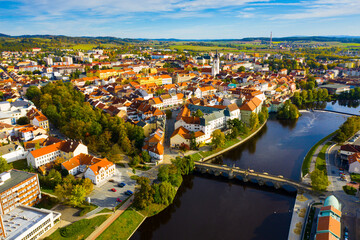 Aerial view of brownish roofs in ancient residential district of Pisek city on Otava river on fall...