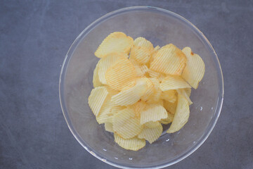 Enjoy a delightful serving of freshly made potato chips presented attractively in a clear bowl