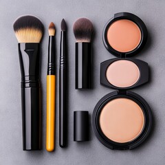 A collection of makeup brushes and cosmetics arranged on a gray surface.