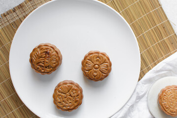 Overhead view of homemade mooncakes, top view of baked mooncakes on white plate, process of making mooncakes for Lunar New Year and mid autumn festival