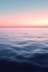 Obraz premium A serene seascape featuring calm waters reflecting soft pastel hues of a sunset, creating a tranquil and peaceful atmosphere over the horizon.