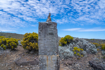 A small cairn made of stacked stones marks the trail leading to the summit of Piton de la Fournaise, an active volcano on Reunion Island. Reunion Island, France.