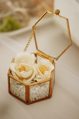 White fresia flower and gift box with diamond ring on color background, top view. High quality photo