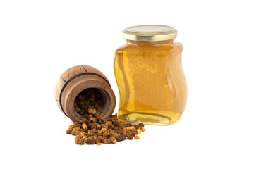 Natural bee bread spilling from a wooden barrel against a white background