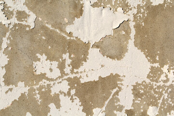 Close-up of a weathered concrete wall with peeling white paint abstract textured background