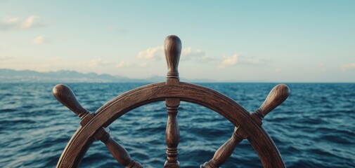 Naklejka premium Ship's wheel against a serene ocean backdrop, clear blue skies.