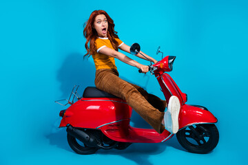 Photo of crazy shocked woman wear stylish clothes drive fast moped isolated on blue color background