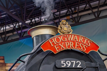 Fototapeta premium 8th Comic Con Convention In GUAYAQUIL, ECUADOR - AUG 06, 2023 - Iconic Hogwarts Express train with steam, displaying the famous crest and sign, perfect for fantasy and magic themes.