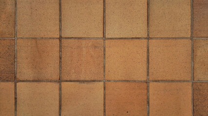 Top view of reddish brown rustic natural stoneware outdoor floor. Classic rough anti-slip matte terracotta ceramic square tiles for paving, terrace, porch, patio, pool exterior texture background. 