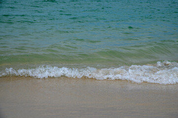 A calm beach with waves gently rolling onto sandy shores