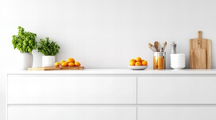 A white kitchen counter with a bowl of oranges, a wooden cutting board, and a glass jar of cooking utensils.