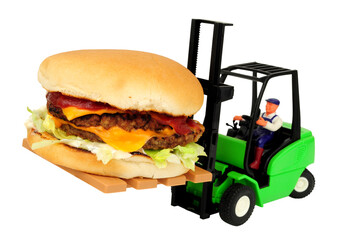 Toy forklift truck carrying a full size double cheese burger with salad and red sauce isolated on a...