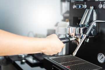  young asian girl barista is making coffee in a cafe using a drip coffee machine Produce high quality coffee