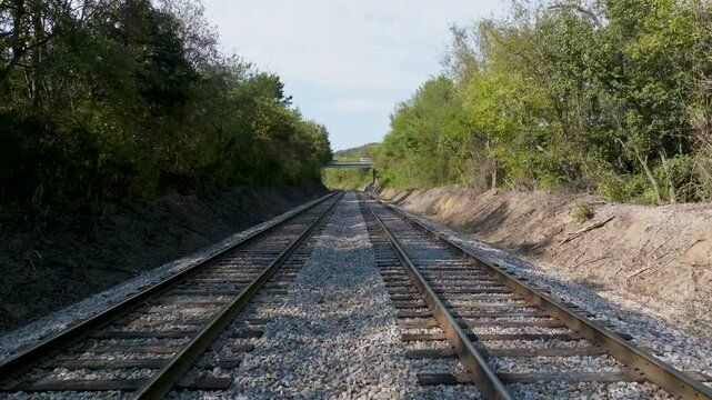 UAV low dolly forward over double railroad tracks.
