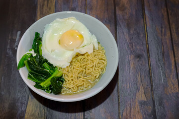 noodles in a bowl with sunny side up egg and vegetables