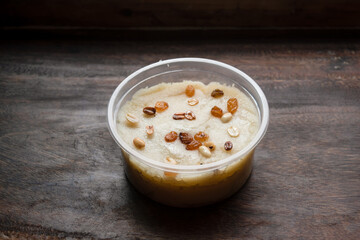 Suji Halwa, Sooji Halawa or Sujir Halua topping with peanut and raisin served in bowl isolated on table side view bangladeshi, indian and pakistani dessert