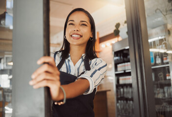 Waitress, woman and happy at entrance of cafe for opening, ready for service and welcome to restaurant. Small business owner, person and smile at doorway of coffee shop for hospitality and confidence