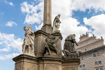 Obraz premium Group of sculptures at the bottom part of Marian Plague Column in garden on Hradcanska Square in Prague in Czech Republic