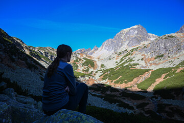 Female hiker enjoying the breathtaking view of the mountain peaks in high tatras, slovakia