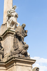 Group of the sculptures at the bottom of Marian Plague Column in the garden on Hradcanska Square in Prague in Czech Republic